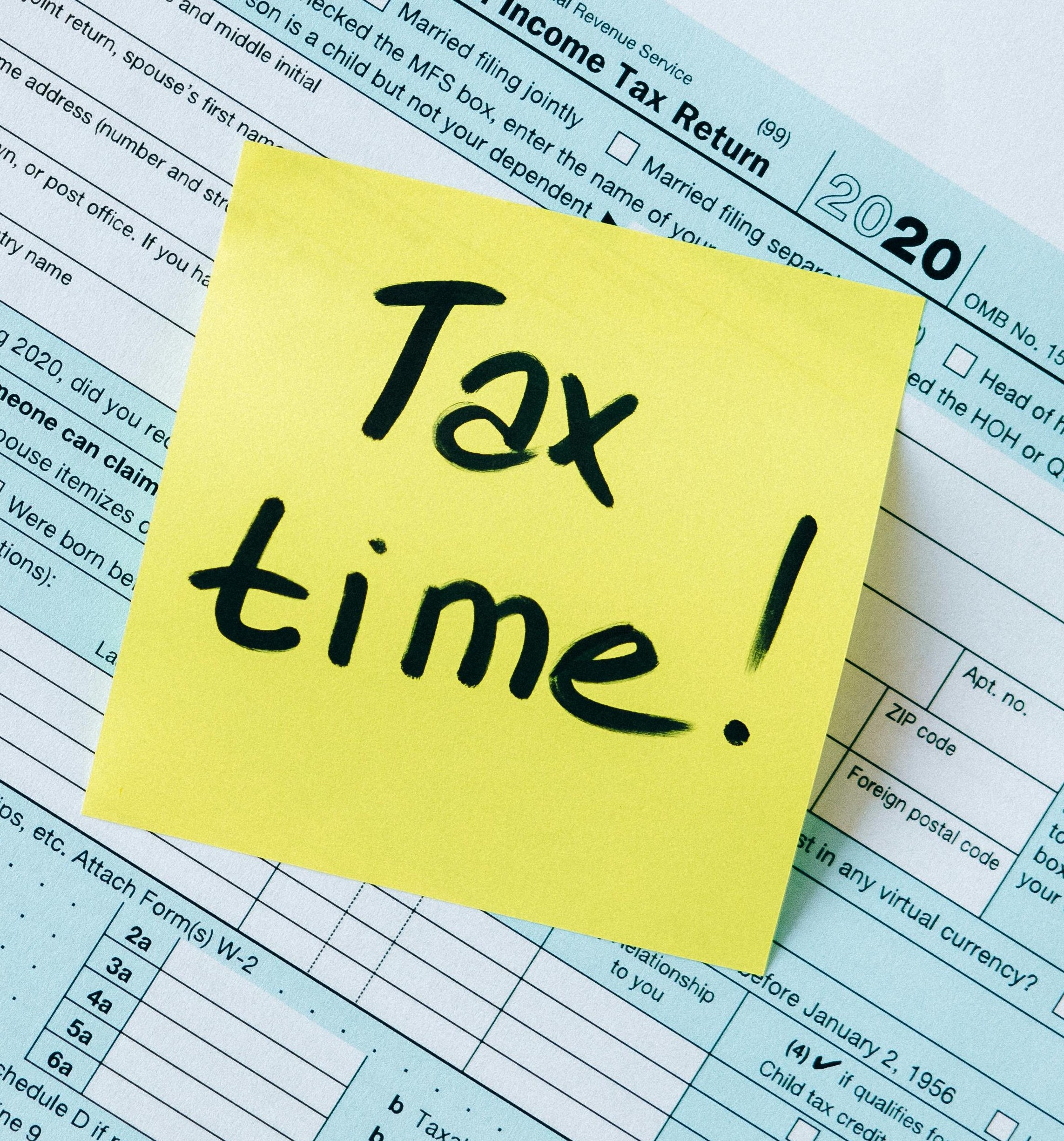 1040 form in background with yellow sticky note that says "Tax Time!"