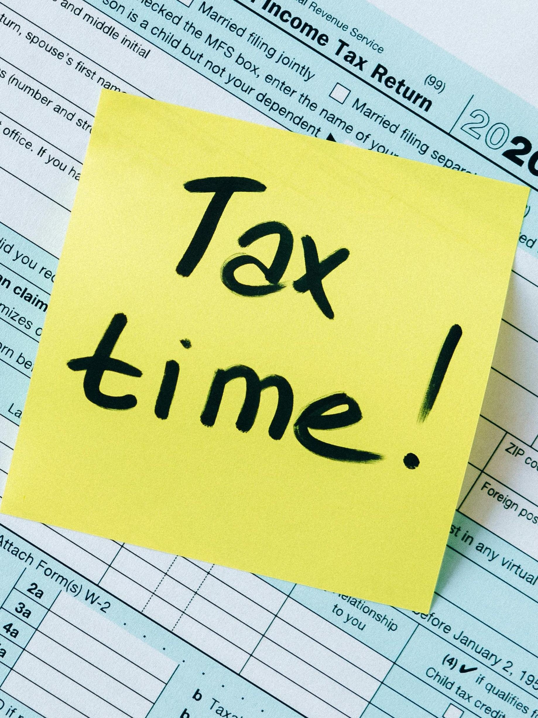 1040 form in background with yellow sticky note that says "Tax Time!"